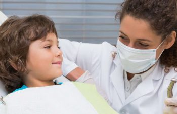 A little boy looks at the dentist before the procedure. They smile.