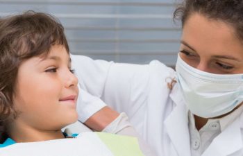 A little boy looks at the dentist before the procedure. They smile.