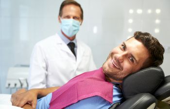 stress-less cheerful male patient in a dental chair after the treatment