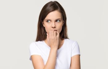 Nervous young woman biting her nails