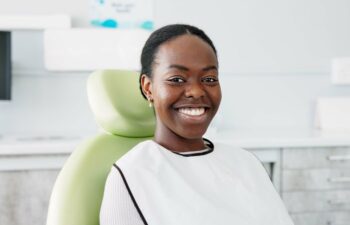 Happy smiling Afro American woman sitting in a dental chair